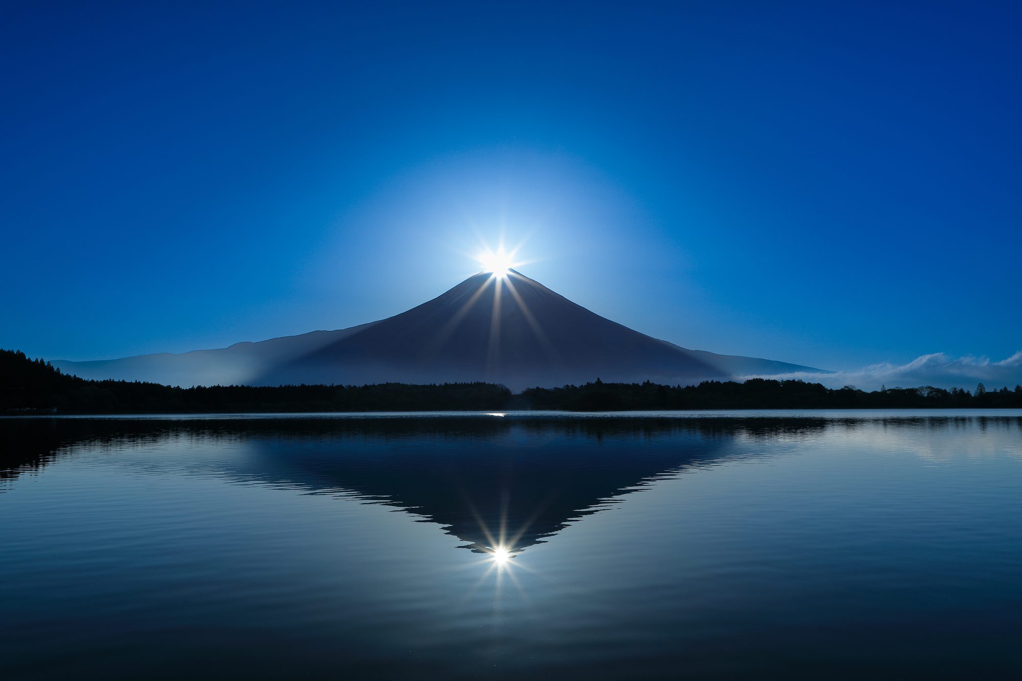 Diamond Fuji — the rising sun crowning Mt. Fuji over a mirror lake